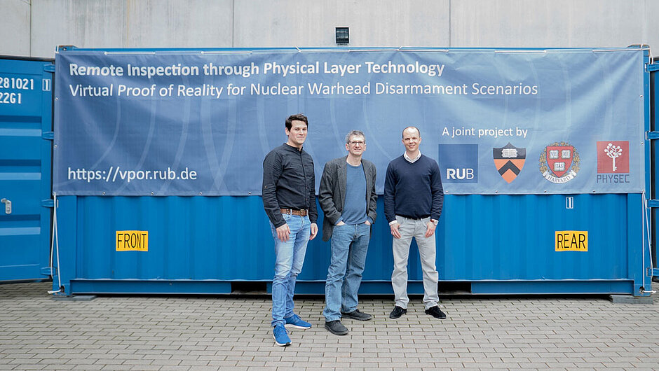 Die PHYSEC Gründer Christian Zenger und Heiko Koepke und Christof Paar vor einem Container mit vpor.rub Banner