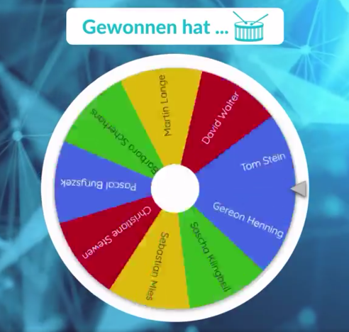 PHYSEC LinkedIn Gewinnspiel Bild auf dem ein Glücksrad mit den Namen der Gewinnspielteilnehmern zusehen ist, über dem Glücksrad steht "Gewonnen hat..." mit einem kleinen Trommelsymbol